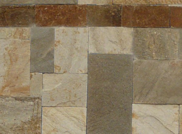 Smooth patterned stone neatly set in wall. A red line of stone divides the pattern at regular intervals.